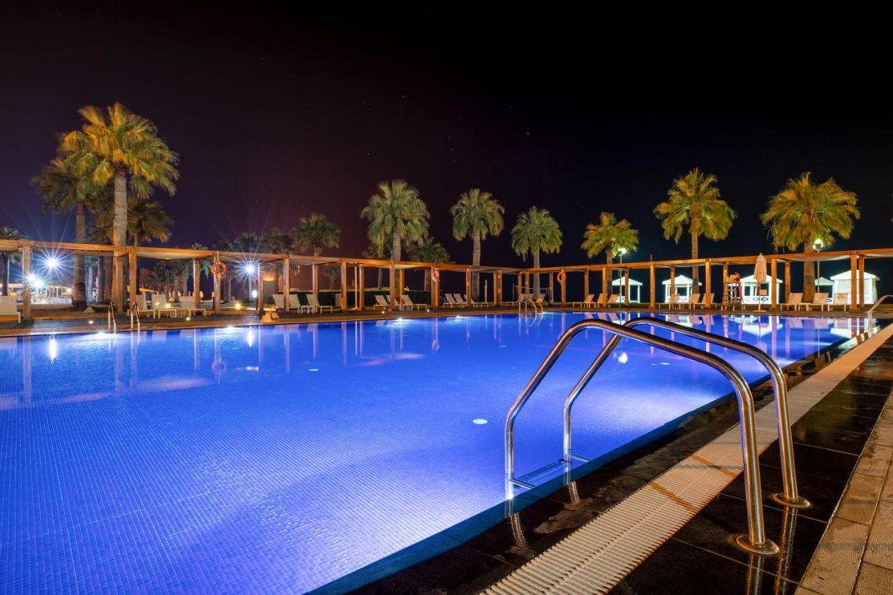 Sealine Beach, A Murwab Resort Musajid Zewnętrze zdjęcie A swimming pool at night
