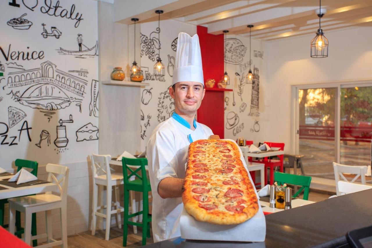 Sealine Beach, A Murwab Resort Musajid Zewnętrze zdjęcie A pizzaiolo with a metre-long pizza